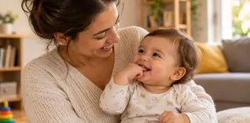 Mãe feliz com seu bebê de colo, em sala na sua casa.
